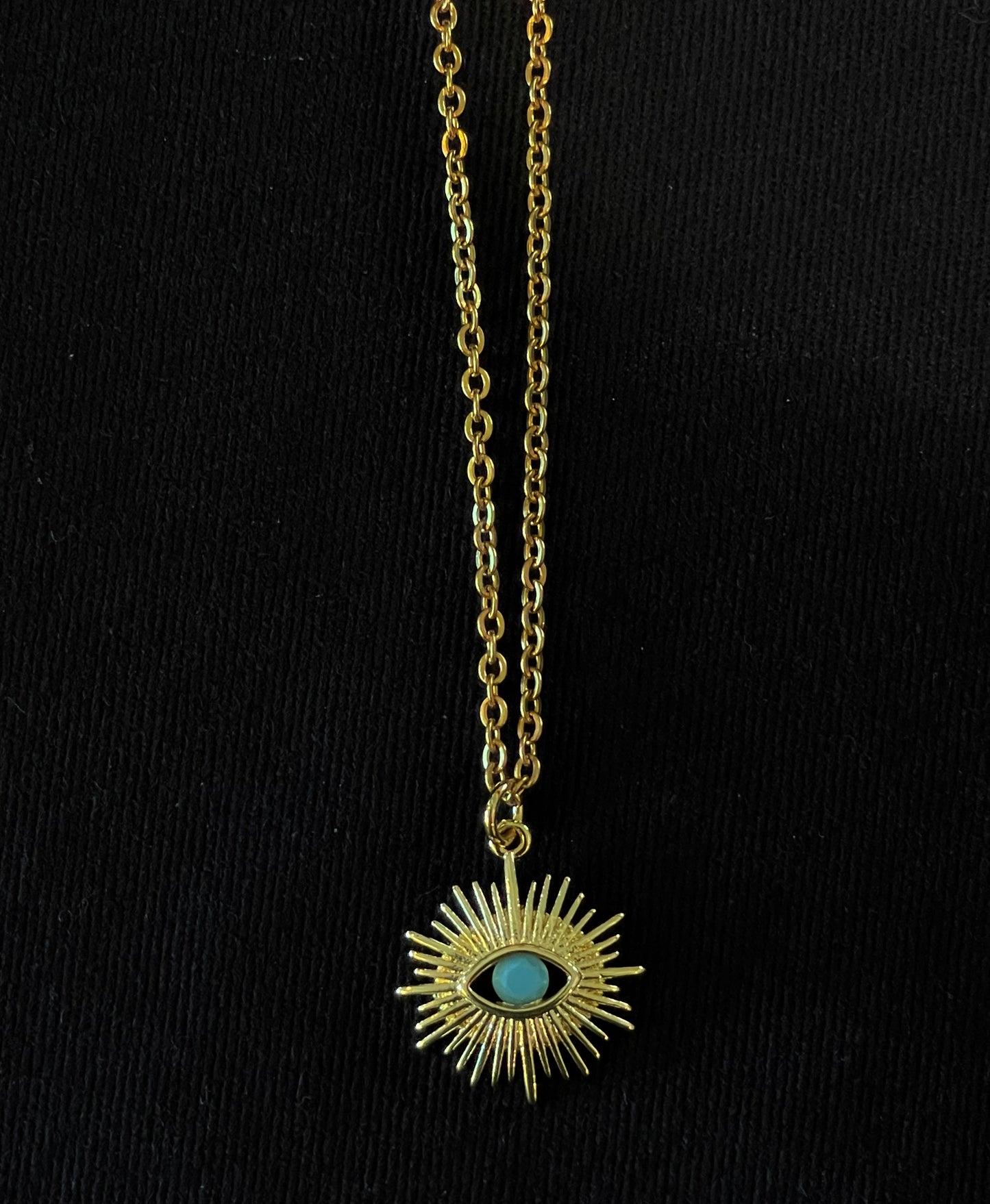 Gold starburst evil eye pendant with turquoise stone on chain
